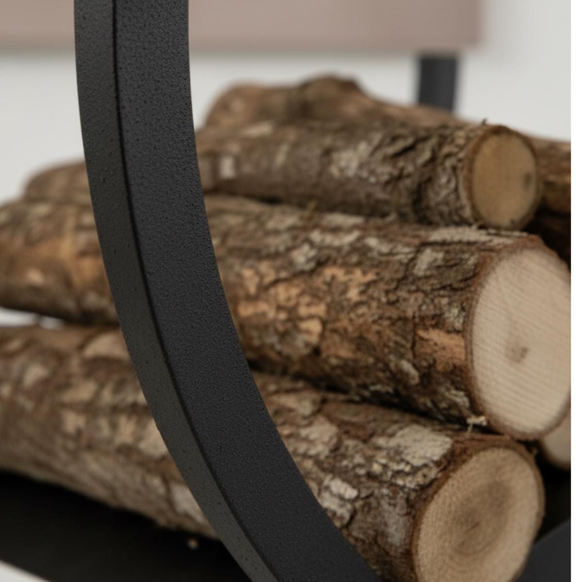 Fireplace log storage rack with curved metal holder designed for indoor use