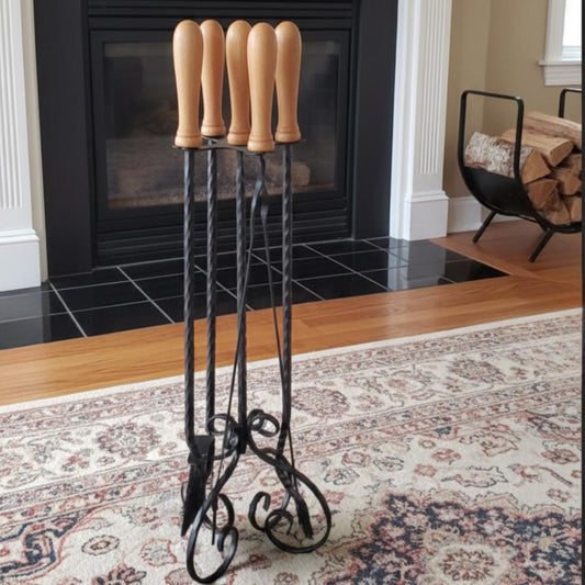 Fireplace tool set wrought iron with wood handles placed near indoor fireplace