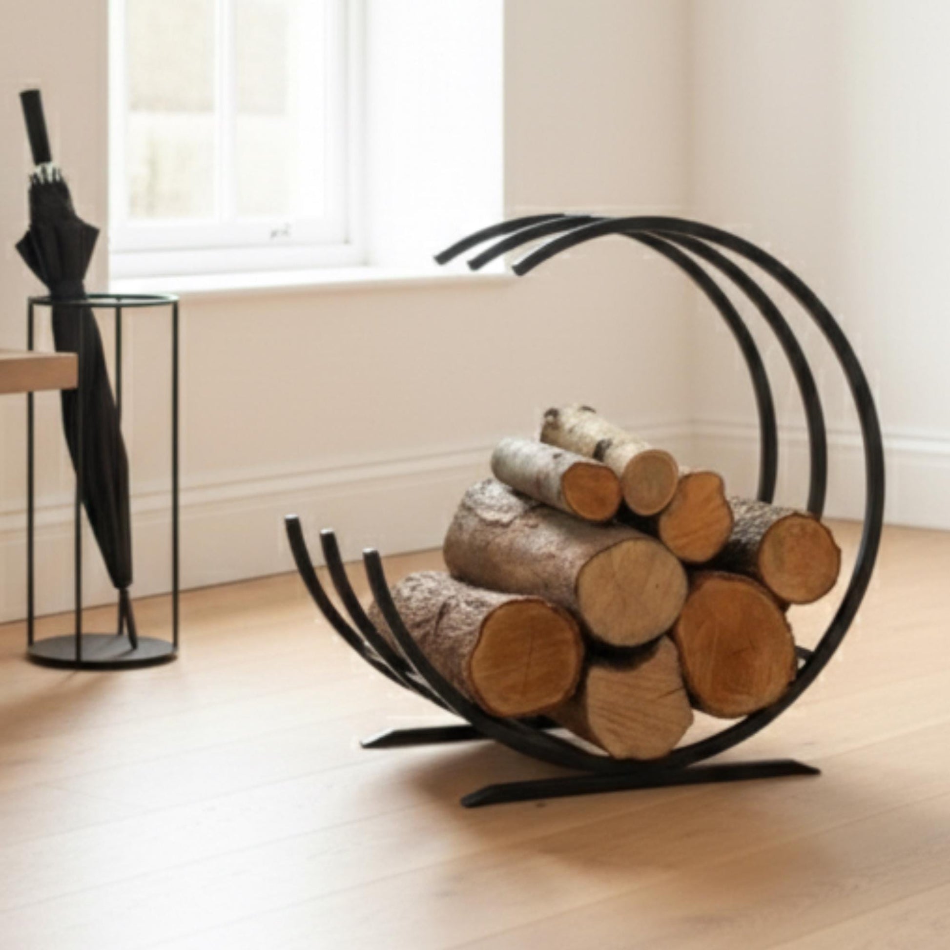 Modern curved firewood rack black metal indoor log holder, minimalist round firewood storage for fireplace, freestanding steel log rack for living room décor, durable powder coated firewood organizer for indoor wood storage
