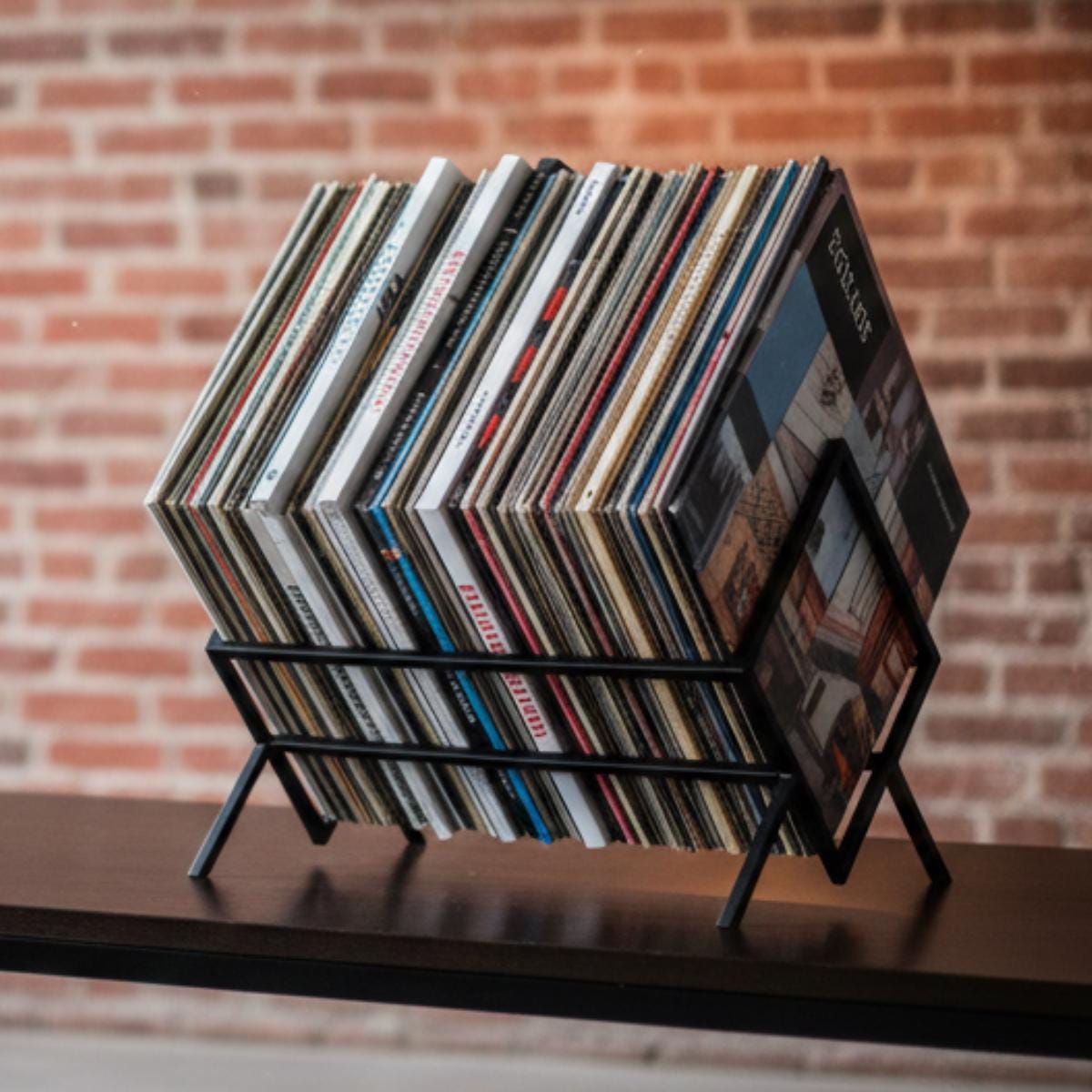 Vinyl record storage rack metal holder placed next to turntable setup in living room